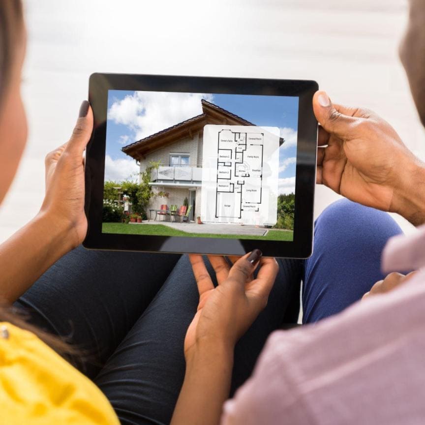 Two people looking at a home floor plan featured on a real estate listing on a tablet computer