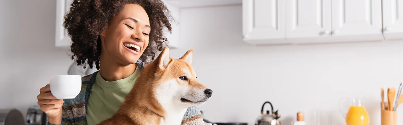 A Happy Woman Holding Her Dog As She Learns All About Dog Poop