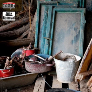 A pile of junk in a basement. There's an old blue door. There are a couple of buckets filled with trash and some old wood. But Clickapro is here to clean it up and remove it.