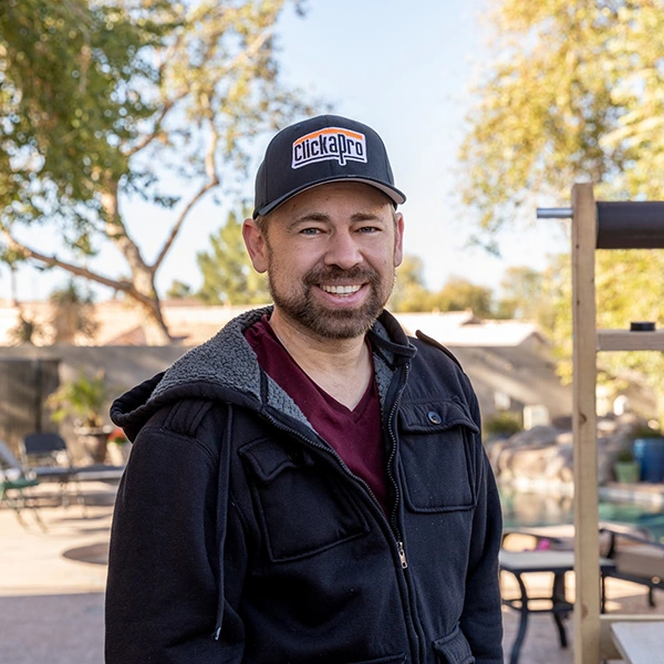 About Clickapro founder Reid Johnson. In this image, Reid is wearing a Clickapro baseball cap and a black jacket.